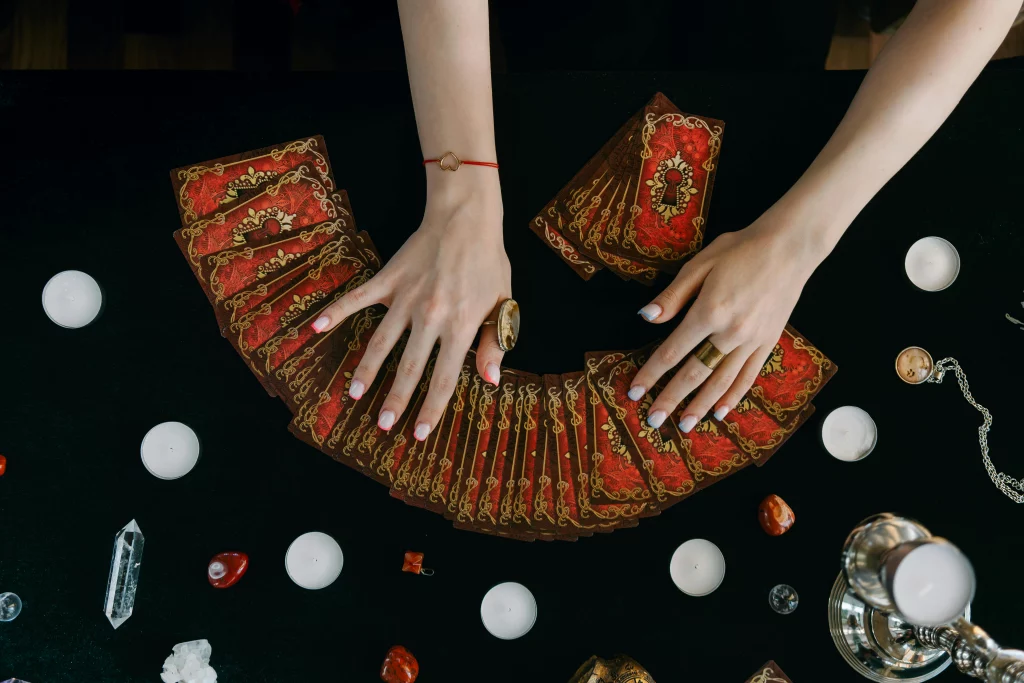 Une femme qui tire les cartes de tarot vue sur ses mains.