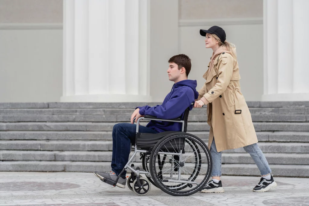 Personne en fauteuil roulant poussé par une autre personne